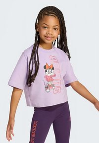 Lilla cropped t-skjorte med korte ermer, med en grafikk av en tegneseriefigur og fete "ADIDAS"-bokstaver; kombinert med mørkelilla leggings.