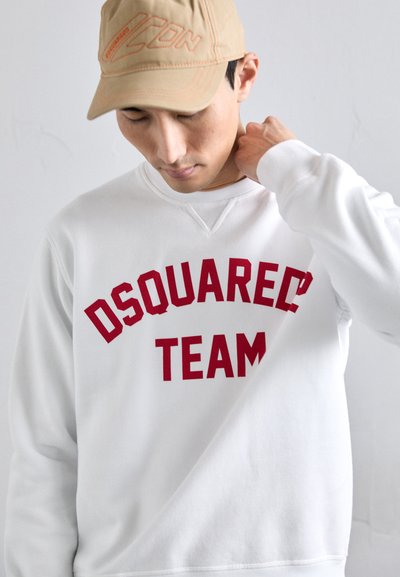 Felpa bianca con "DSQUARED2 TEAM" stampato in rosso audace sul petto. Collo rotondo, maniche lunghe, vestibilità rilassata. Materiale in morbido cotone.