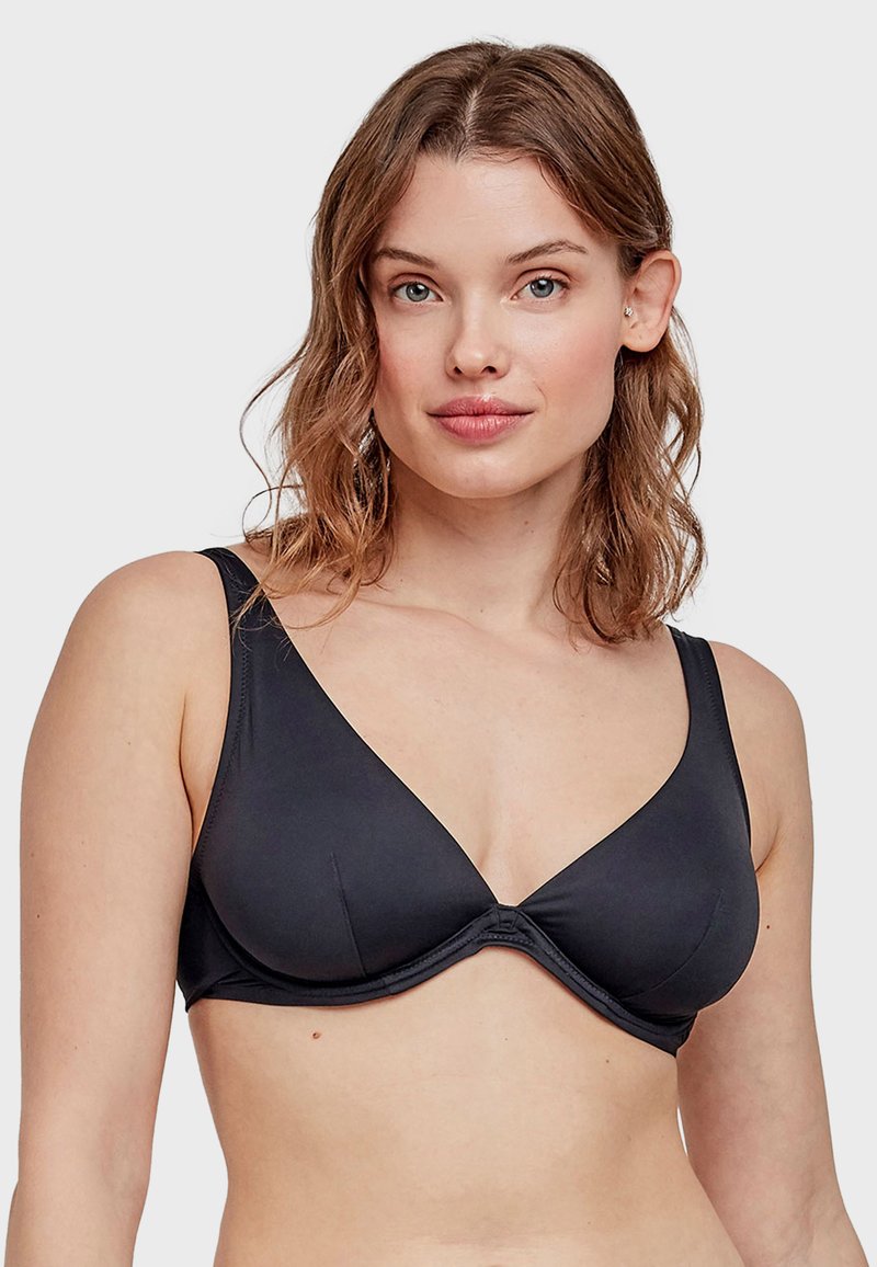 Reggiseno nero con una finitura in tessuto liscio, design a scollo a V profondo, spalline larghe e una cucitura vicino al centro. Nessun hardware o decorazione visibile.