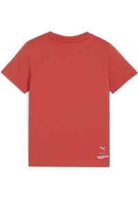 Camiseta de algodón roja con mangas cortas, cuello redondo y un pequeño logo de Puma blanco y un detalle de diseño cerca del dobladillo. Textura suave.