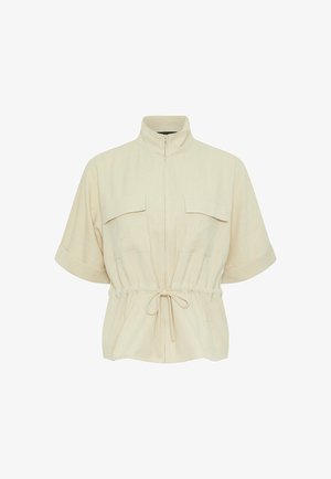 Chaqueta beige de manga corta con cuello alto, cremallera frontal, dos bolsillos con solapa en el pecho y cintura ajustable con cordón.