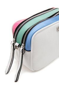 Witte leren cosmetica tas met drie ritscompartimenten in roze, groen en blauw. Voorzien van zilveren hardware en zwarte accenten.