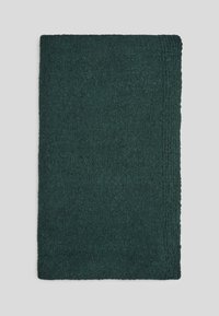 Tapis de bain rectangulaire vert foncé avec une surface texturée et un design de bordure linéaire subtile sur un fond clair.