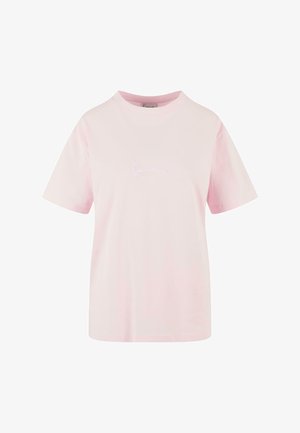 Rozā kokvilnas T-krekls ar īsām piedurknēm un apaļu kakla izgriezumu. Priekšpusē ir vienkāršs balts izšūts logotips.