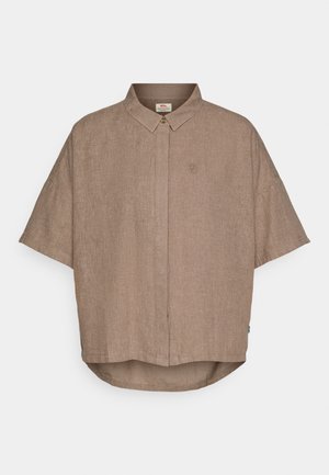 Brun linneskjorte med kort erm, knappestolpe og en liten logo på venstre side. Buet havn nederst.