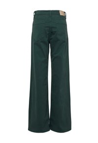 Weite Hosen aus dunkelgrünem Baumwollstoff. Mit einer mittelhohen Taille, zwei Gesäßtaschen und einem beigen Patch am Taillenbund.
