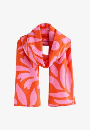 Bright orange scarf with large pink abstract leaf patterns, folded and draped against a white background.