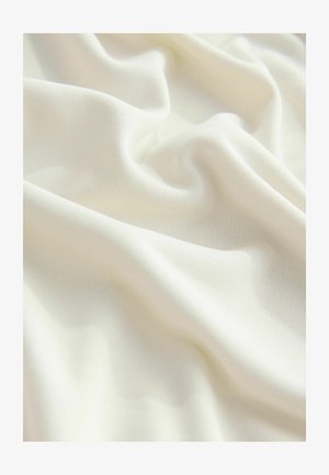 Tissu beige clair avec une texture lisse et douce, affichant un léger nervuré et des plis doux, idéal pour divers usages textiles.