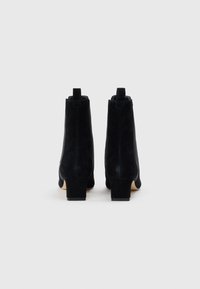 Botine negre din nubuc, cu vârf pătrat, toc bloc și detaliu cu buclă în spate. Textură netedă, fără modele vizibile.