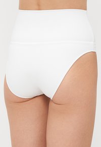Chiloți albi cu talie înaltă, fără cusături, realizati dintr-un material neted și elastic, cu un design minimalist și margini curate.