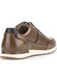 Bruine leren sneaker met een ronde neus, zwarte accenten bij de hiel, een witte zool en gestructureerde details aan de bovenkant.
