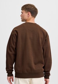 Brun, genser med rund hals laget av mykt stoff, med lange ermer og ribbede mansjetter, med et enkelt, udecorert design.