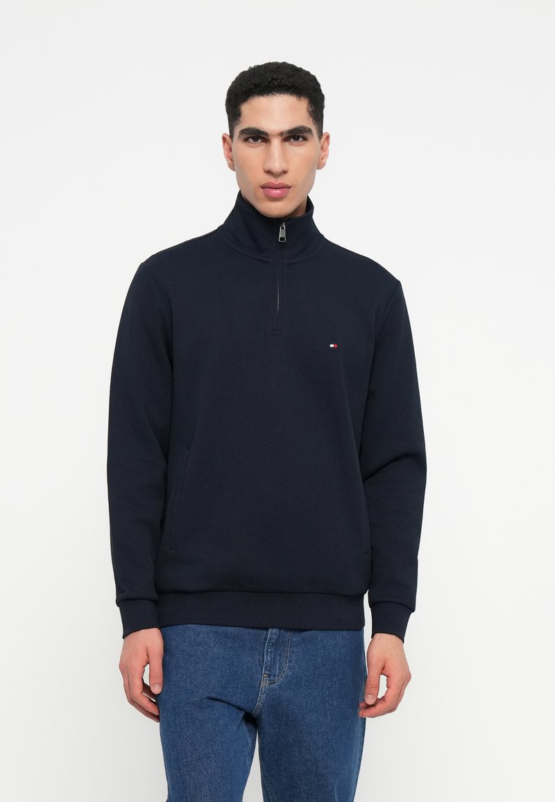 Marineblauw zip-up sweatshirt met hoge kraag, voorzien van een klein logo op de borst, gemaakt van zachte stof met geribbelde manchetten en zoom.