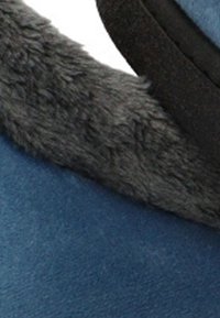 Zapatilla de ante azul con un suave forro de piel sintética gris oscuro, de textura lisa y forma redondeada. Diseño sencillo y funcional.