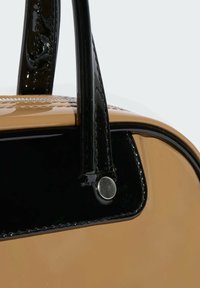 Χρυσή τσάντα ώμου με γυαλιστερές μαύρες λεπτομέρειες, λεία επιφάνεια και γυαλιστερές μαύρες λαβές. Διαθέτει ασημένιο κούμπωμα και λεπτομέρειες ραφής.