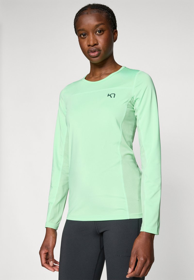 Jasnozielona, długosleeve'owa koszulka sportowa z okrągłym dekoltem, z logo na piersi i teksturowanymi siateczkowymi panelami bocznymi.