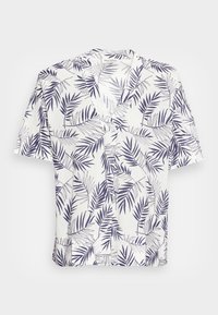 Chemise à manches courtes en tissu léger, avec une base blanche ornée d'un motif de feuilles bleu marine et un col cranté.