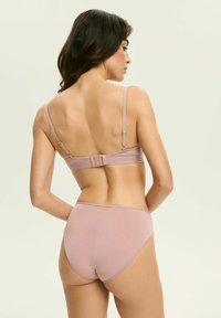 Jasnoróżowy zestaw biustonosza i majtek, który posiada regulowane ramiączka, zapięcie na haftki oraz gładką, bezszwową fakturę. Subtelne akcenty siateczkowe na majtkach.
