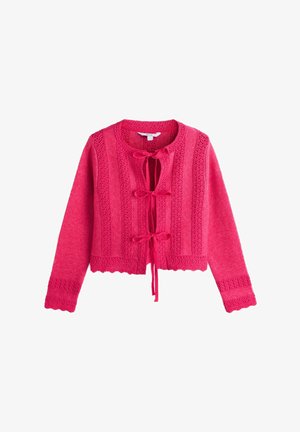 Lyserød strikket cropped cardigan med lange ærmer, dekorative lodrette mønstre, bølgede kanter og tre bundne sløjfer ned foran.