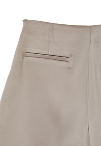 Tessuto di raso beige con tasca posteriore a welt piatta e cuciture visibili su un indumento, probabilmente pantaloni o una gonna.