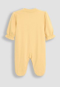 Monito amarillo de algodón con mangas cortas abullonadas, puños con volantes y diseño con pies. La vista trasera muestra un escote redondo y sin cierres.