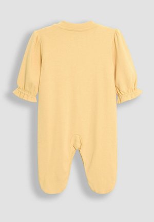 Sárga pamut egybeöltöny rövid puffos ujjakkal, fodros mandzsettákkal és cipzár nélküli lábfejes kialakítással. A hátoldalon lekerekített nyakvonal látható, nincs rajta zárás.