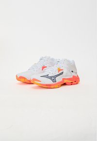 White athletic shoes with a textured upper, highlighted by grey accents and bright orange soles. Features laces and a cushioned design.