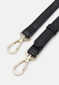 Svart läderrem med guldfärgad hårdvara, med två klippfästen och en jämn textur. Stickade detaljer synliga längs kanterna.