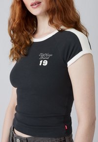 Černé tričko s krátkým rukávem a bílými akcenty s vyšíváním "TwoHorse Brand 19". Měkká tkanina s přiléhavým střihem. Červená nášivka na lemu.