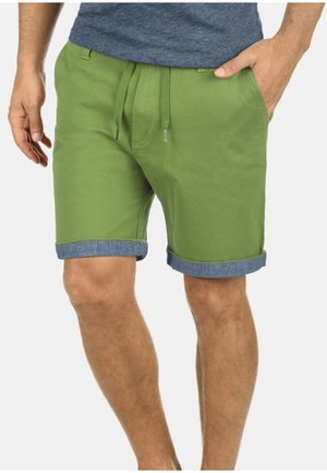 Scurtă verde din bumbac, cu talie cu șnur, având un tiv din denim la margine și buzunare laterale.