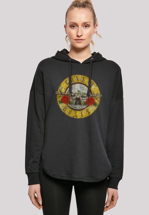 Schwarzer Kapuzenpullover mit einem grafischen Aufdruck eines kreisförmigen Logos mit einer Pistole und Rosen. Das Design hat eine gelbe und graue Farbgestaltung.