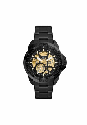 Czarny zegarek Fossil z metallicznym szkieletem tarczy, ozdobiony złotymi akcentami, z bransoletą połączoną oraz wyraźnymi znacznikami godzin. Regulowane zapięcie.