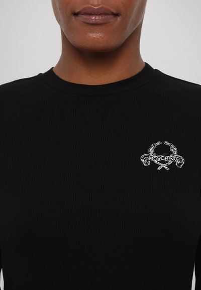 Bluza neagră din material ribbed cu mânecă lungă, având un logo brodat alb cu textul "Moschino" și elemente încrucișate pe piept. Gât clasic de tip crew.
