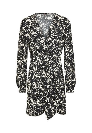 Robe imprimée en noir et blanc avec des manches longues, décolleté en V profond, taille cintrée et jupe ample et fluide, présentant un détail à nouer sur le devant.