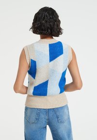 Sleeveless knit vest in blue and beige, featuring geometric patterns. Material appears soft with a ribbed hem. Back view shows neck detail.