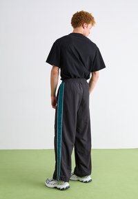 Puma PLAY PARIS TRACK PANTS - Tepláky - black