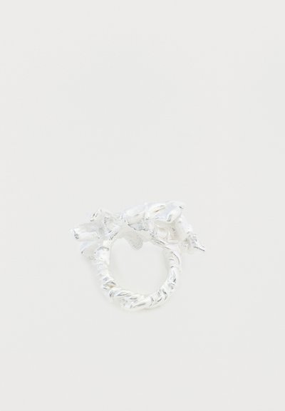 Anillo de plata con un diseño orgánico y retorcido, con detalles texturizados que imitan formas naturales. Acabado liso, forma redonda.