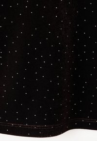 Crna tkanina s suptilnim uzorkom malih bijelih točaka, glatke teksture s blagim sjajem, obrubljen rub i bez vidljivih metalnih dijelova.