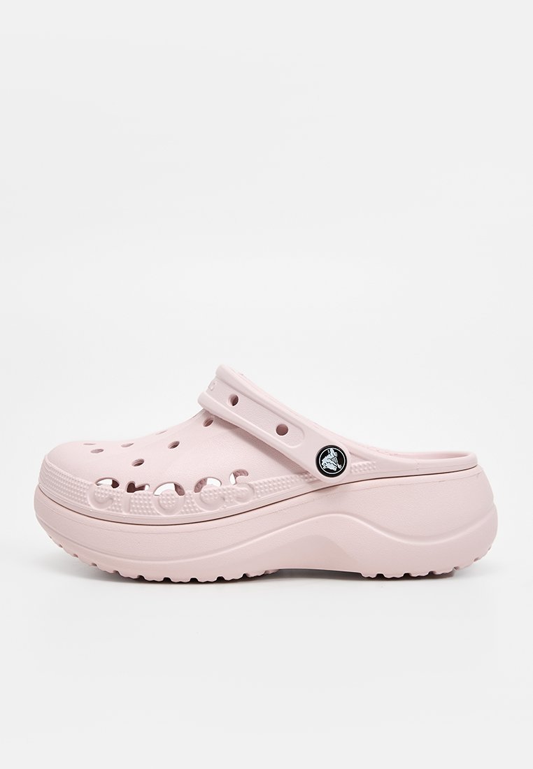 Zuecos de espuma en un suave color rosa claro, con agujeros de ventilación, una correa trasera y una suela texturizada. Presenta un logotipo negro en el lateral. Material suave y duradero.