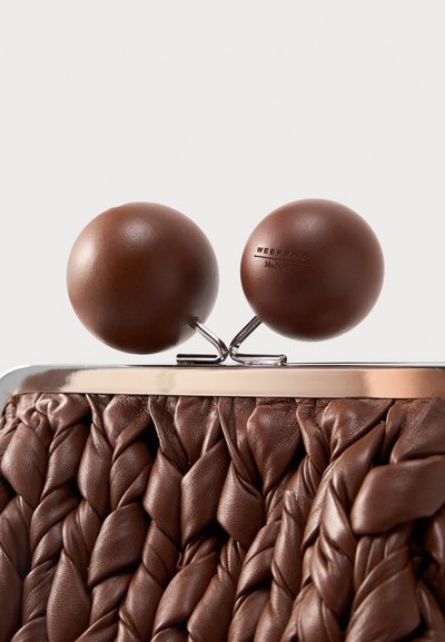 Καφέ πλεκτό δερμάτινο τσαντάκι με μεγάλα στρογγυλά κουμπιά κλεισίματος και ασημένιο πλαίσιο, που αναδεικνύει την υφή και τις λεπτομέρειες του κλεισίματος.