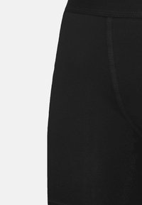 Pantaloni corti neri in tessuto morbido, con una cintura alta e cuciture piatte, progettati per il comfort e la libertà di movimento.