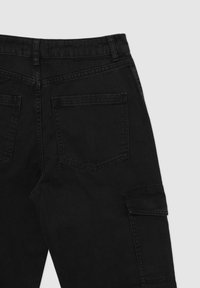 Pantaloni in denim nero con vita alta, due tasche posteriori e una tasca cargo laterale; presentano cuciture robuste e una texture liscia.