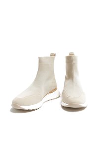 Beige nazouvací kotníkové boty vyrobené z pleteného materiálu s texturovaným vzorem a gumovou podrážkou. Mají hladký špičku a mírný podpatek.