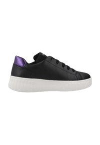 Zapatilla de cuero negro con suela blanca, cuenta con un brillante detalle morado en el talón, cinco ojales para los cordones y textura suave.