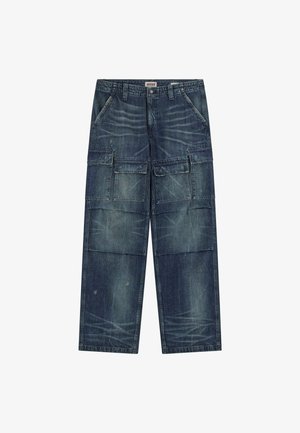 Pantaloni cargo in denim blu scuro, con molteplici tasche frontali e laterali, una vestibilità comoda, cuciture in vista e una finitura leggermente usurata.