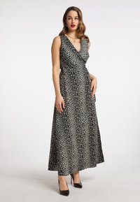 Rochie maxi cu print leopard, având un decolteu în V și un design tip wrap. Material moale, fără mâneci, siluetă fluidă, asortată cu tocuri negre.