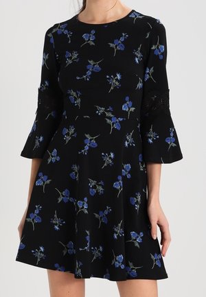 Zwarte jurk met blauw bloemenprint, getailleerde taille en driekwart klokmouwen met kanten inzetstukken.