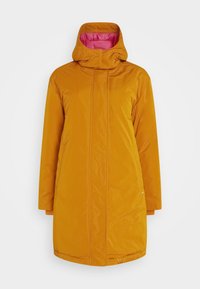 Long manteau d'hiver rembourré orange avec col montant et capuche, doté d'une doublure rose à l'intérieur de la capuche et de poches latérales.