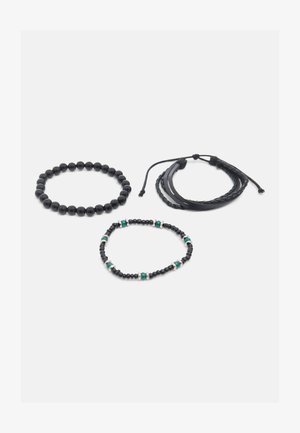 Tri čierne náramky: jeden s guľatými korálkami, jeden s malými korálkami a zelenými akcentmi a jeden pletený kožený náramok s nastaviteľnými šnúrkami.
