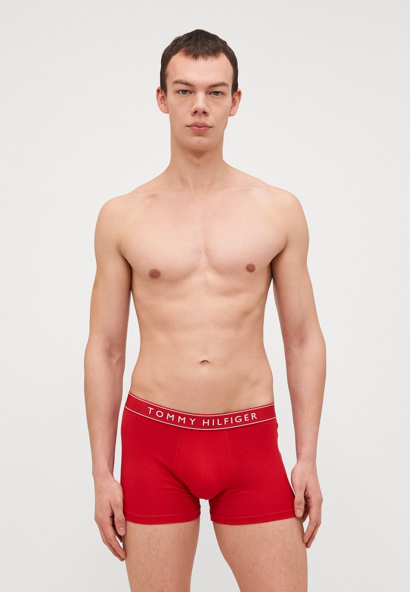Czerwone bawełniane slipy z białą gumką z logo "TOMMY HILFIGER". Gładki materiał, dopasowany krój, długość do połowy uda.
